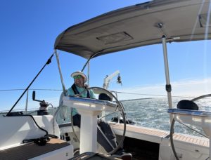 charles smiles from the starboard helm of a bavaria 42 while sailing in the charleston harbor