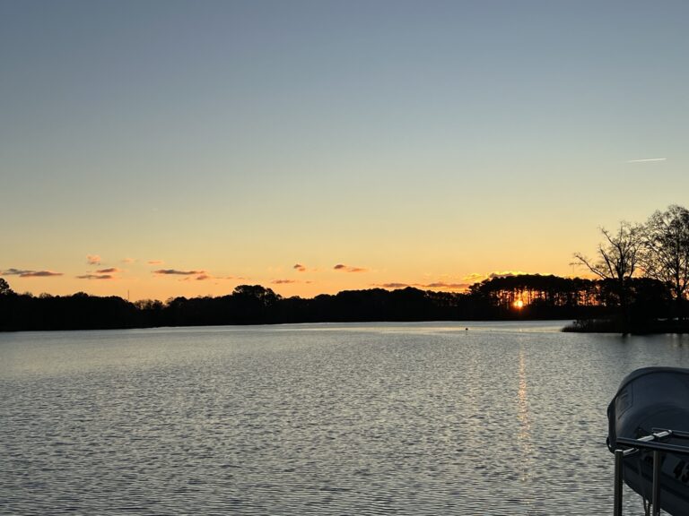dark blue sky above with a gradient down to yellow showing the sunrise over a dark blue large body of water