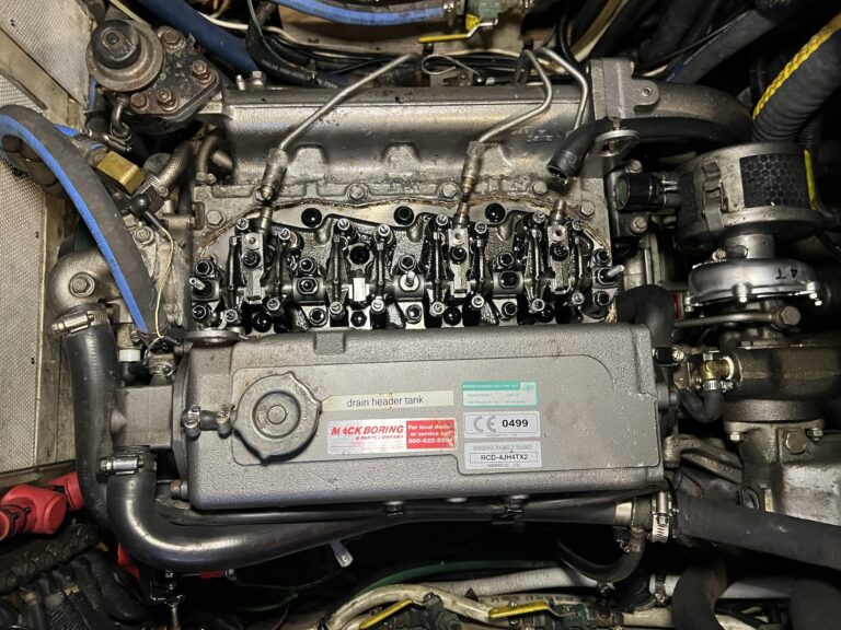 Looking down at the top of a 4-cylinder diesel engine with the valve cover off. Lots of metal tubing and oil-coated parts are in view, and the #3 fuel intake is missing. The turbo is to the right, and the front of the motor is to the left.