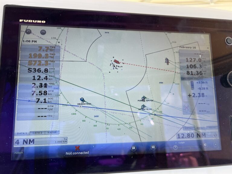 A chart plotter screen shows wind data, boat speed, and other metrics on each side, along with showing boats that are nearby on AIS