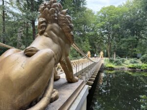 A golden bridge in a park with lions at each end
